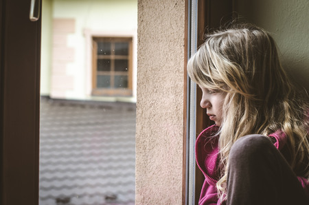 beautiful blond girl looking through window
