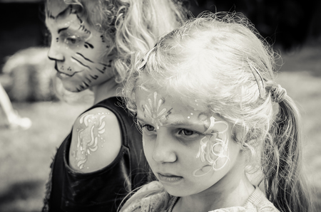 little lovely blond girls with colorful facepainting の写真素材