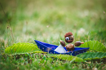 cute autumn figures made of chestnut material posing in the grassの写真素材