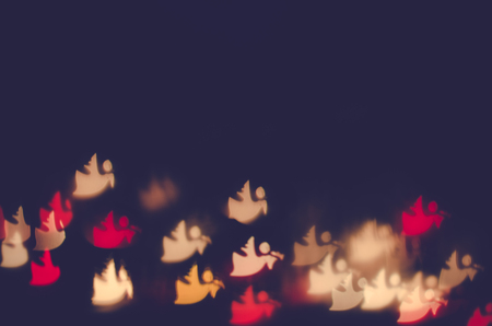 christmas angel bokeh against dark backgroundの写真素材