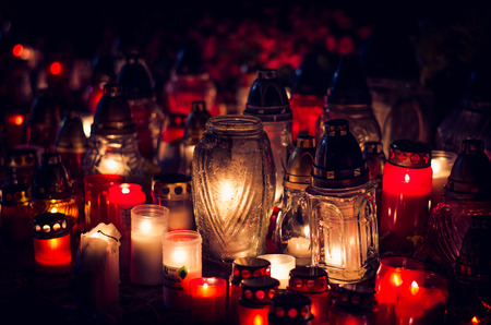 candles burning in lanterns at night during All Saints Dayの写真素材