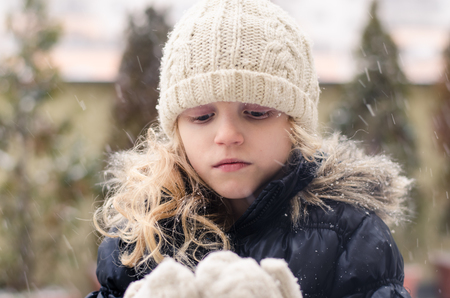 lovely little blond girl playing with snowの写真素材