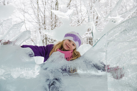 little blond girl with ice sculptures in forest の写真素材
