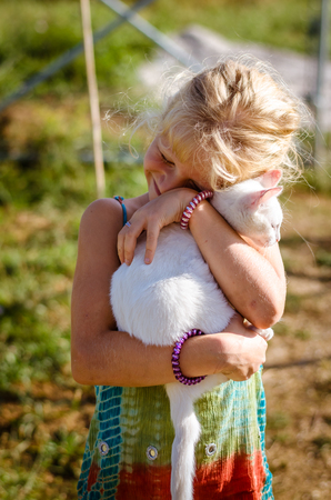 adorable cute kitty cat in hands of little child girlの写真素材