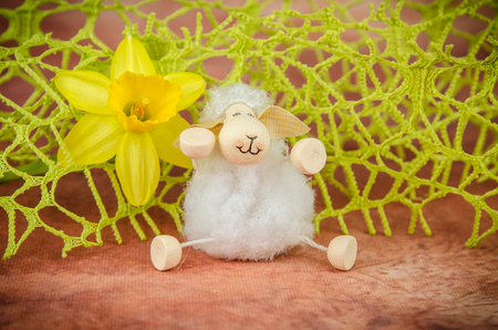 yellow daffodil and sheep decoration against brown backgroundの写真素材