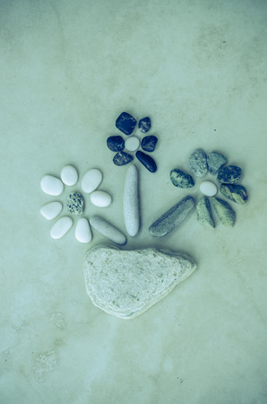 stony flowers in pot made from small pebblesの写真素材