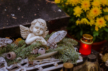decoration of angel in grave in the cemetery at All Saints Day in autumn timeの写真素材