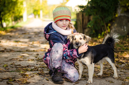 little lovely child with dog pet in handsの写真素材