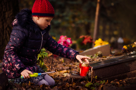 child burning candle during  All Saints Day at the cemeteryの写真素材