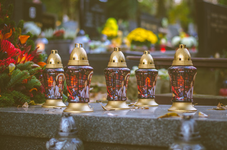 Colorful  burning candles during All Saints Day at the cemetery in autumnal atmosphereの写真素材