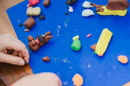 Kids playing with play dough on the tableの写真素材