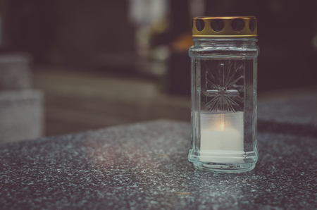 Burning candle decoration in the cemetery at All Saints Day in autumn time monochromeの写真素材