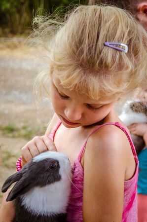 adorable little girl holding fluffy bunnyの写真素材