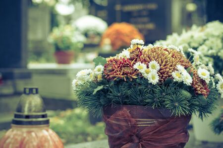 bouquet of colorful flowers during christian All Saints Day event lying in the tomb in the cemeteryの写真素材