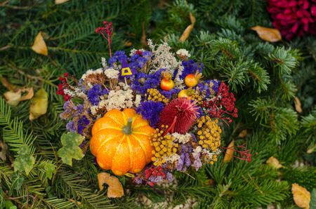 bouquet of colorful flowers during christian All Saints Day event lying in the tomb in the cemeteryの写真素材