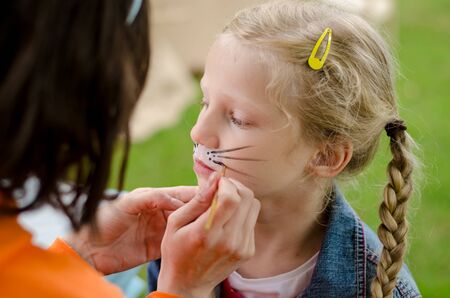 little lovely girl waiting for mouse face painting to be done