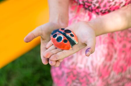 Ladybug gypsum decoration held by girls hand