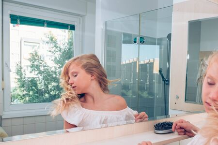 close up portrait of adorable girl with long blond hair in the bathroomの写真素材
