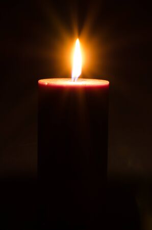 burial concept with burning candle against black backgroundの写真素材