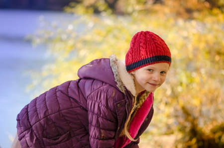 little child holding domestic cat and walking alone in sunny autumnal atmosphereの写真素材