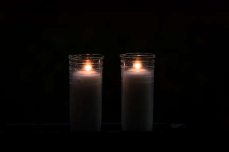 burning candles, colorful flowers and festive decorations on graves in graveyardの写真素材