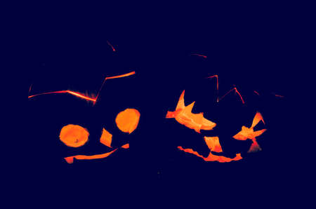 cute artificial halloween orange pumpkin decoration made from paper and glass with burning candle insideの写真素材