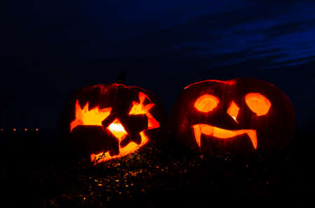 cute artificial halloween orange pumpkin decoration made from paper and glass with burning candle insideの写真素材