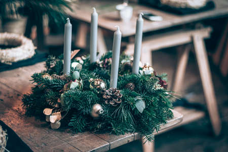 burning candles, scissors and green twigs components on wooden tableの写真素材