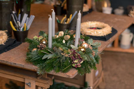burning candles, scissors and green twigs components on wooden tableの写真素材
