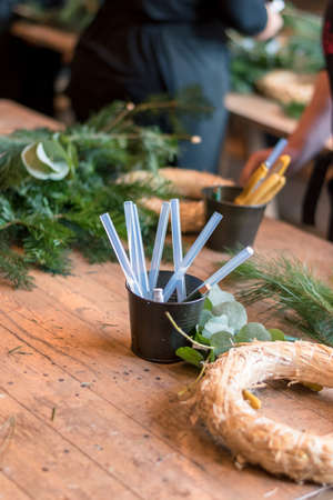 burning candles, scissors and green twigs components on wooden tableの写真素材