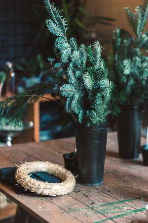 burning candles, scissors and green twigs components on wooden tableの写真素材