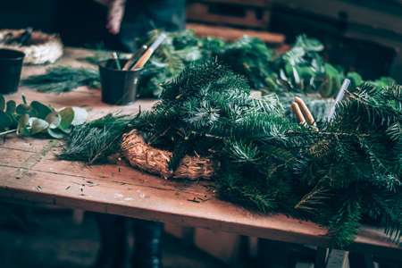 burning candles, scissors and green twigs components on wooden tableの写真素材