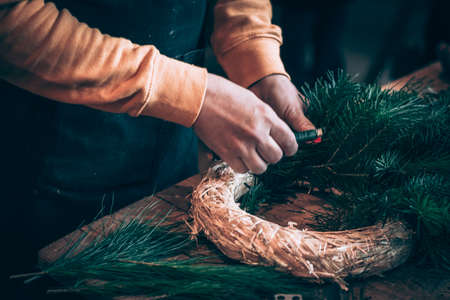 burning candles, scissors and green twigs components on wooden tableの写真素材