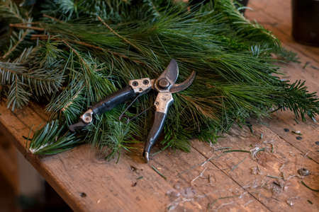 burning candles, scissors and green twigs components on wooden tableの写真素材