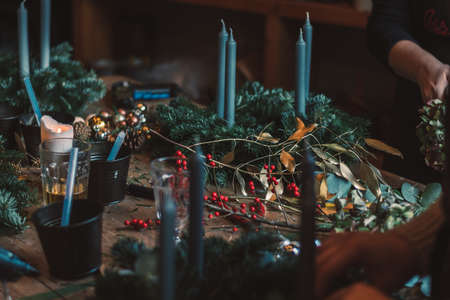 burning candles, scissors and green twigs components on wooden tableの写真素材