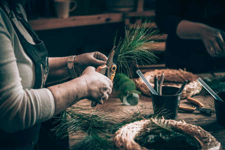 burning candles, scissors and green twigs components on wooden tableの写真素材