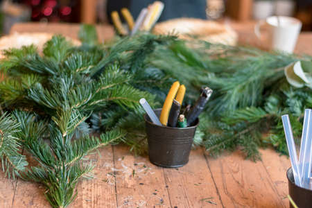 burning candles, scissors and green twigs components on wooden tableの写真素材
