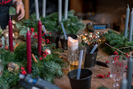 burning candles, scissors and green twigs components on wooden tableの写真素材