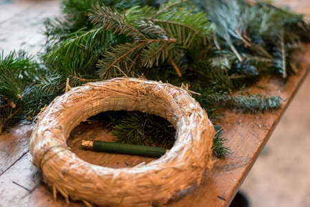 burning candles, scissors and green twigs components on wooden tableの写真素材
