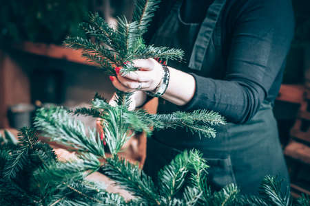 burning candles, scissors and green twigs components on wooden tableの写真素材