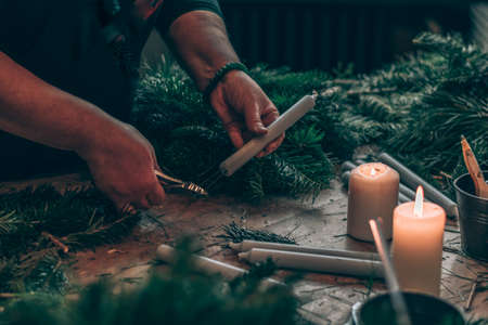 burning candles, scissors and green twigs components on wooden tableの写真素材