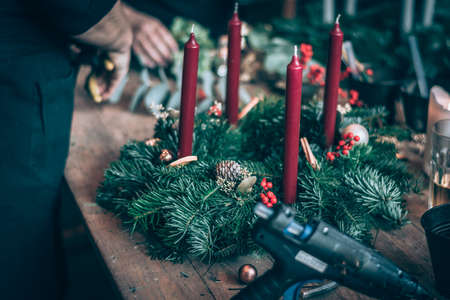 burning candles, scissors and green twigs components on wooden tableの写真素材