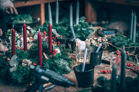 burning candles, scissors and green twigs components on wooden tableの写真素材