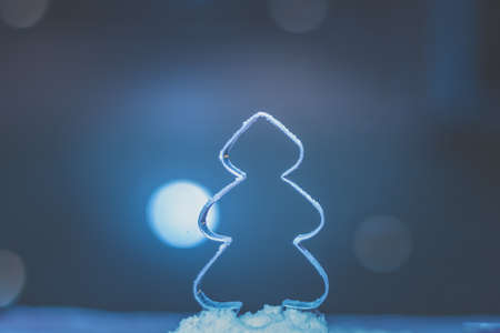 christmas tree mold shape with falling flour snow and bokeh backgroundの写真素材