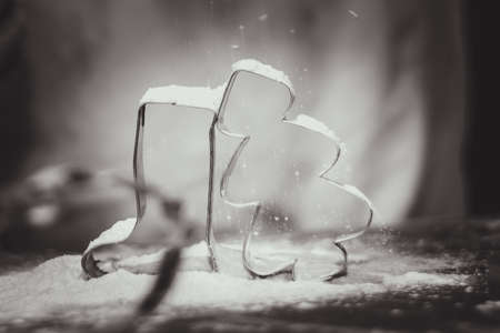 cookies and cooking mold shapes with falling flour in christmas atmosphere