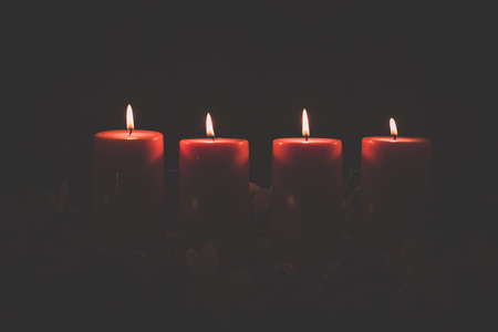 four burning candles with traditional festive cristian atmosphere full of light and magicの写真素材
