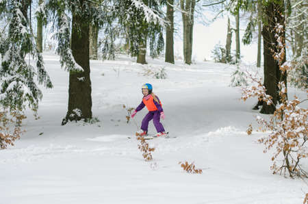 adorable girl in winter forest enjoying snowy atmosphereの写真素材
