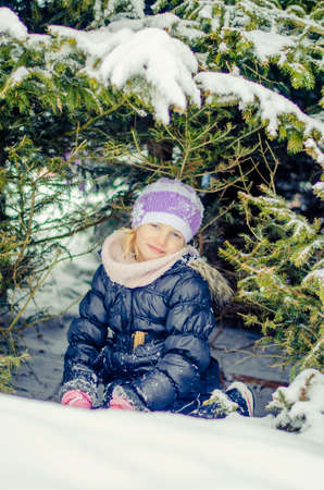 adorable girl in winter forest enjoying snowy atmosphereの写真素材