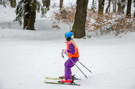 two beautiful girl having fun with snowman in winter forestの写真素材