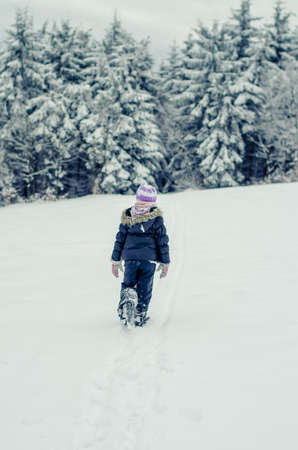 two beautiful girl having fun with snowman in winter forestの写真素材